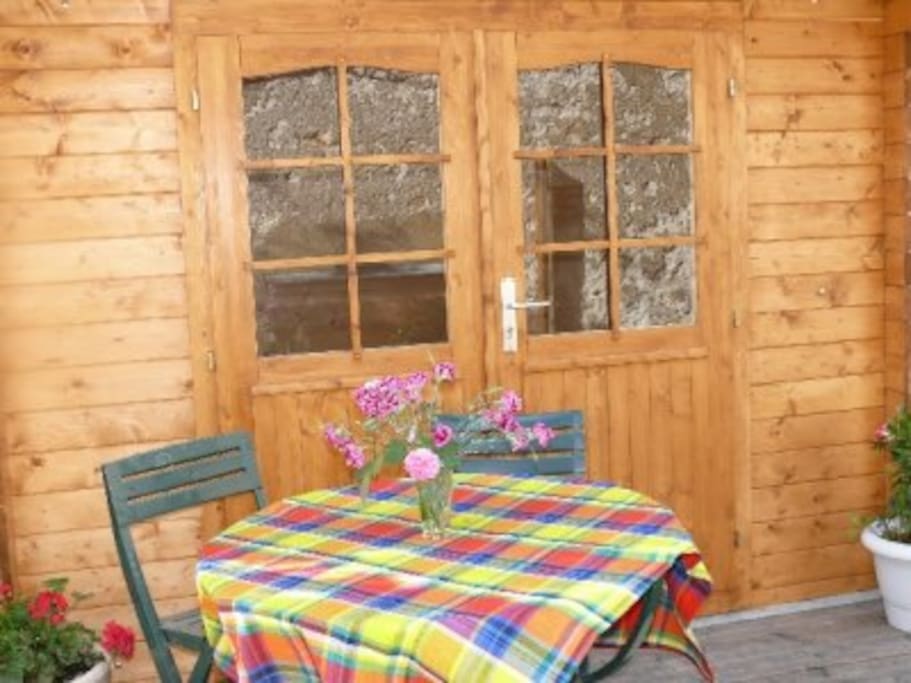Terrasse avec cabane on y trouve salon de jardin, transats, barbecue