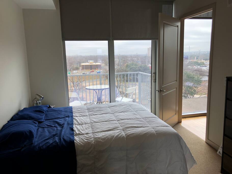 Bedroom with queen mattress, floor-to-ceiling windows and retractable shades