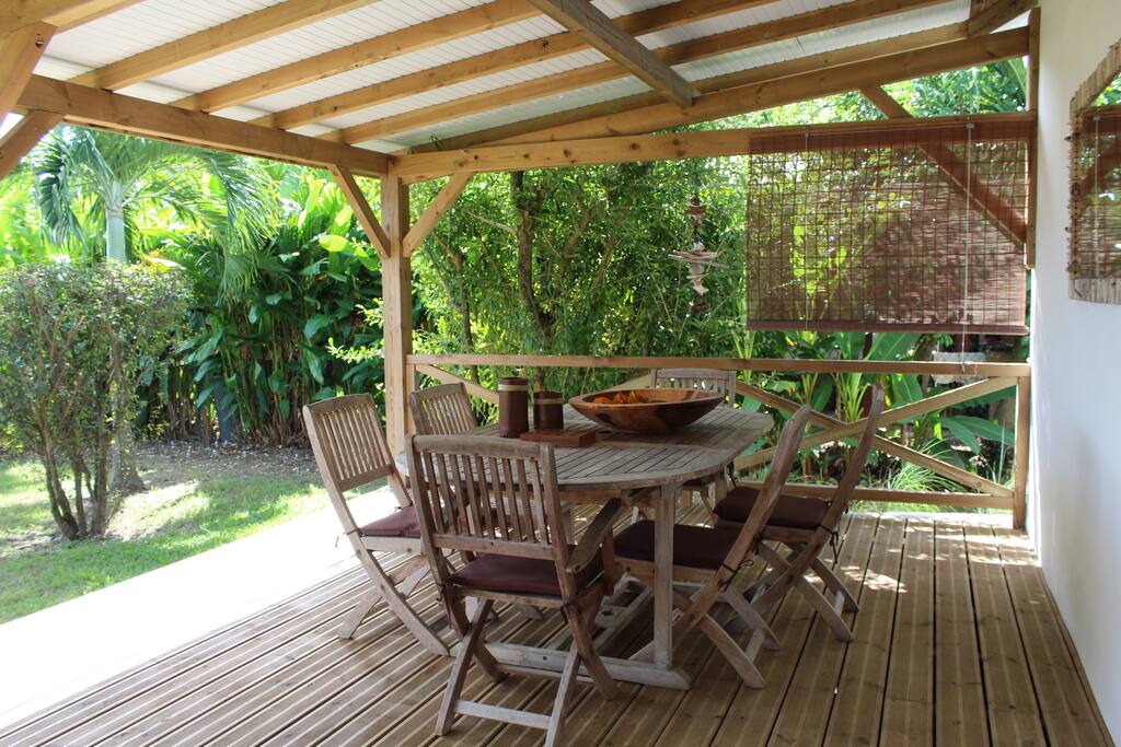Votre espace repas et repos sur une grande terrasse ouvrant sur un vaste jardin clos avec cocotiers, manguiers, bananiers, acérola...