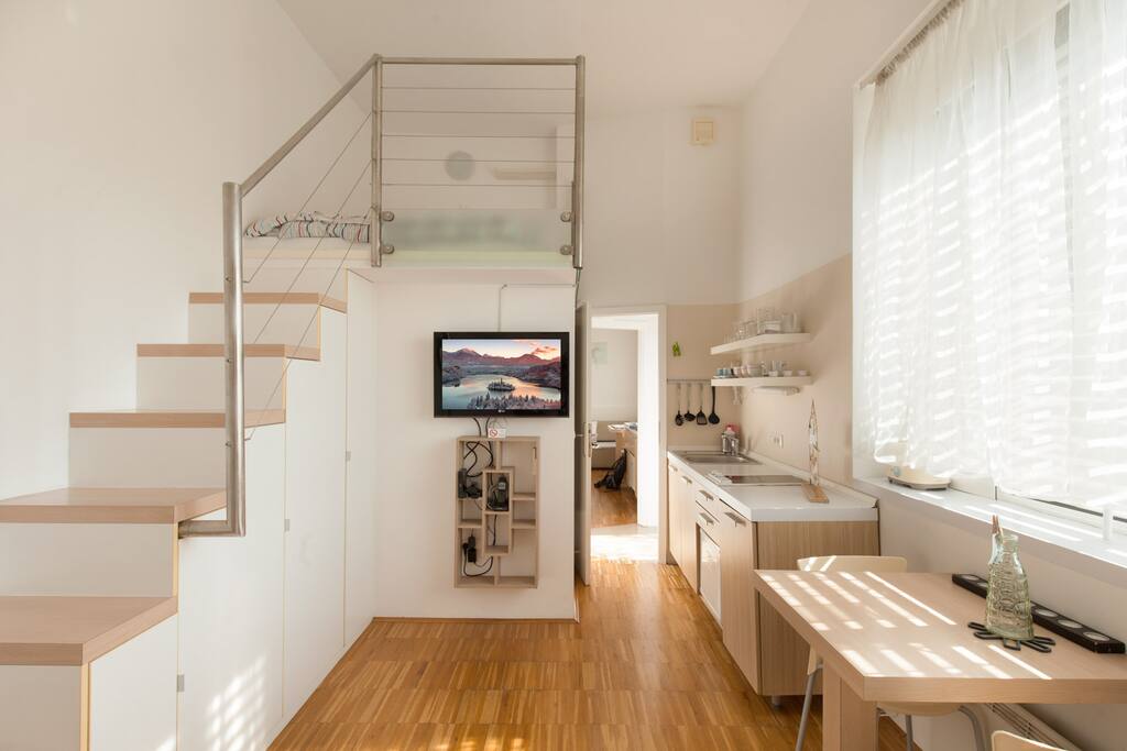 Apartment Urban 1 - kitchen with dining/ working table and a TV corner, double bed on the gallery