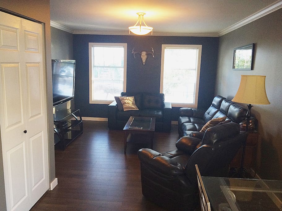 Large living room with 60 inch flatscreen tv, with Apple TV and wifi. Closet and dining table.