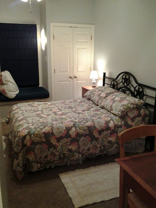 A cozy private suite, featuring a full size bed, a private attached bathroom with bath tub and shower.