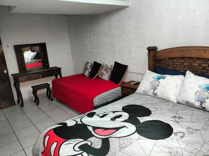 Habitación principal con cama matrimonial e individual.