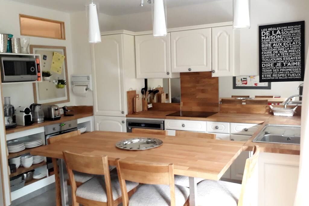 Table de déjeuner et 6 chaises hautes, ouvrant sur une cuisine super équipée et le salon