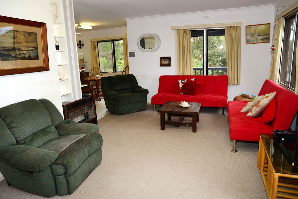 Living Room, Gas Heater, TV, Coffee Table, 3 Couches, 2 Recliners, AC unit on Wall