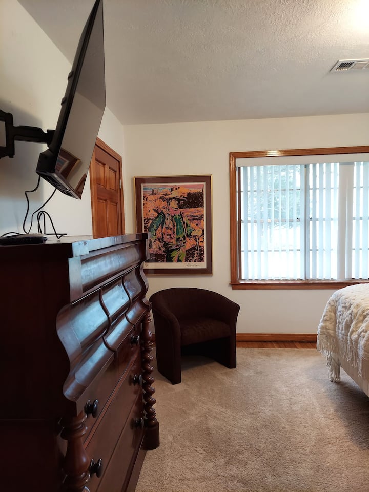 غرفة نوم ثانية بسرير وتلفزيون بحجم كبير