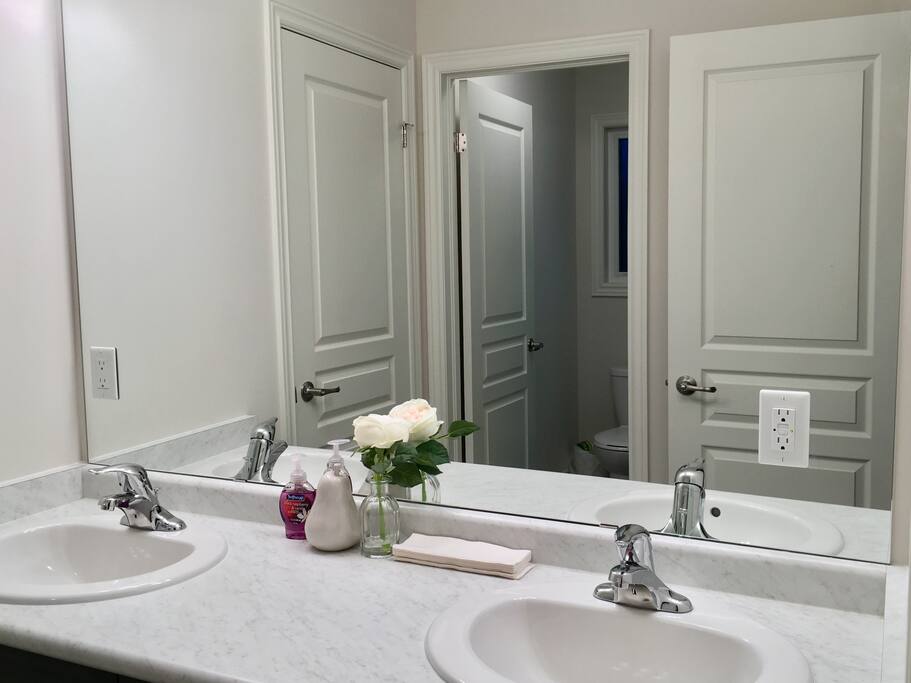 attached washroom with a separate door for a toilet and bath tub use