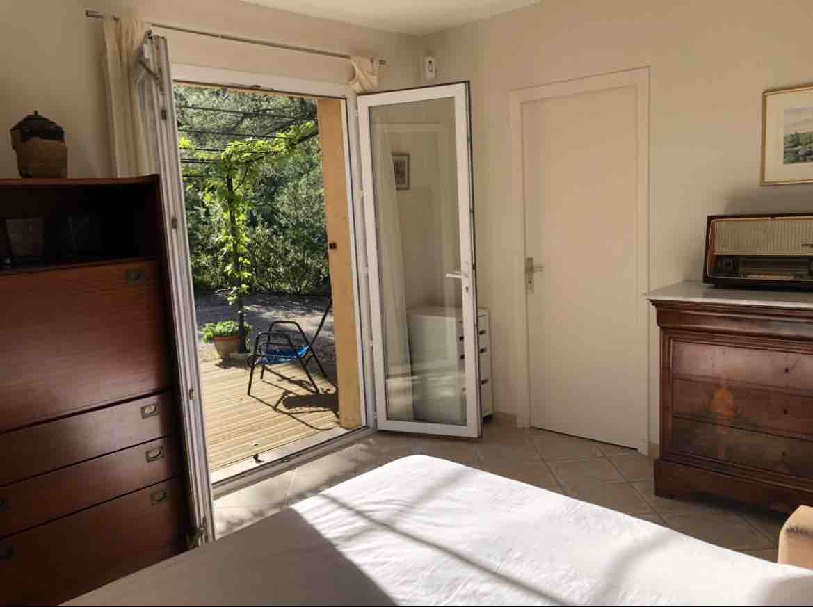 Spavaća soba 1. Sofa. Prozorska vrata koja vode na terasu s pergolom.