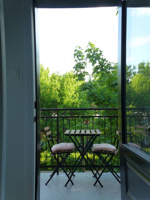 View out the front balcony door, with a small bistro table and 2 chairs.