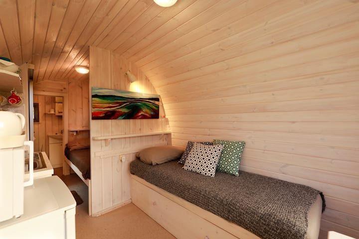 Tiny house Barelio overview from the front; sofa bed, double bed, and in the back of the bathroom , to the left the kitchen block 