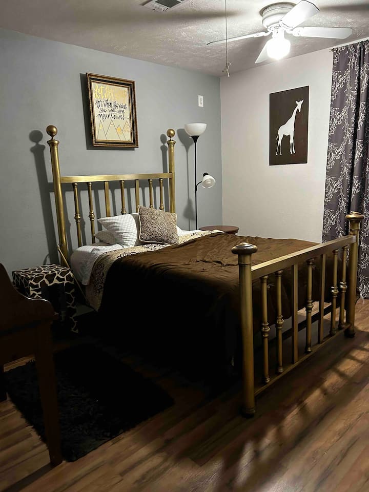 Soba s žirafama na katu ima bračni krevet, zavjese za zamračivanje sobe. 