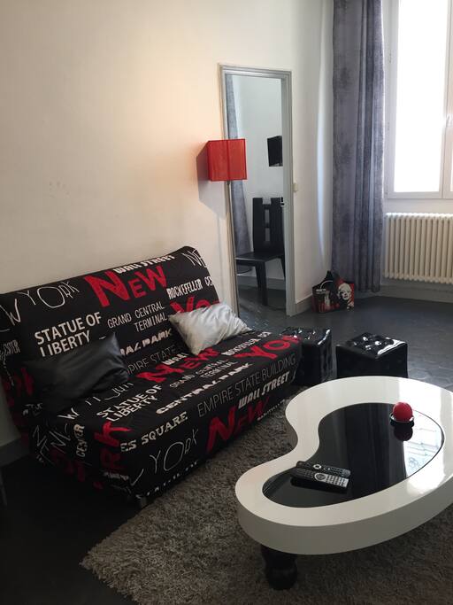 Salon avec coin repas et sofa bed, tv, AC, wifi.