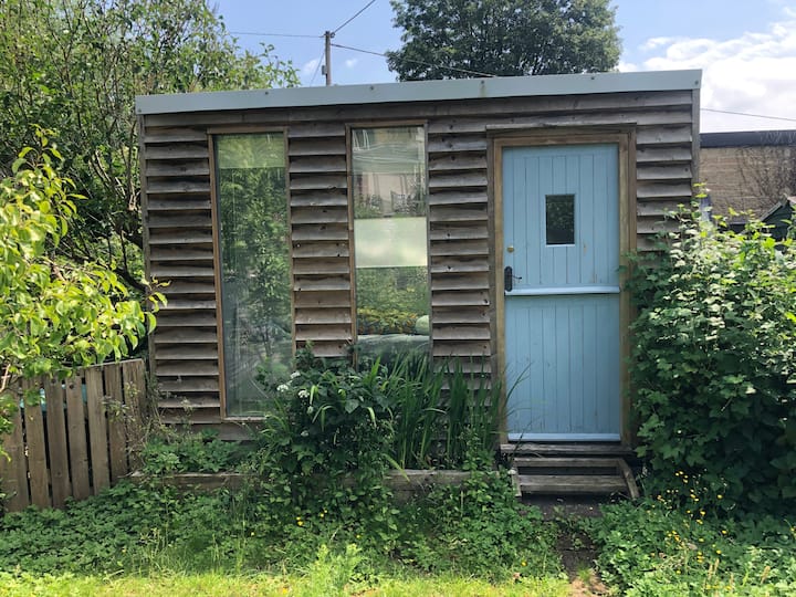 Garden studio with double bed. Insulated & cosy & has heater but no plumbing/ loo - just need to walk up garden to bathroom at back of cottage. Please note, part of room is used for storage!)
