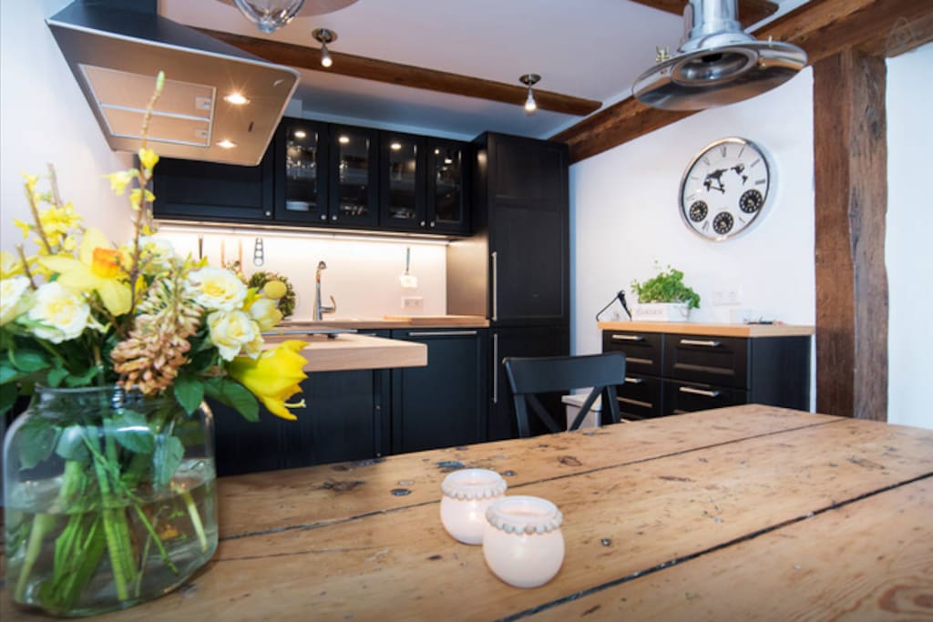 Front: 300 year old door transformed into a table, background: the modern kitchen