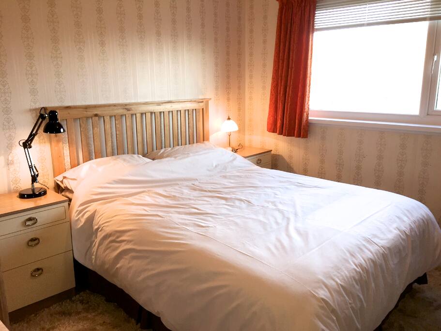 Bedroom with king size bed, wash hand basin and built in wardrobes.