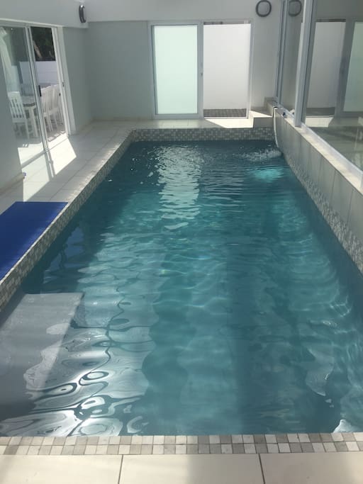 Indoor heated swimming pool with doors leading to sun deck