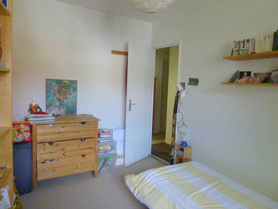 La chambre vue de la fenêtre : la commode et le lit