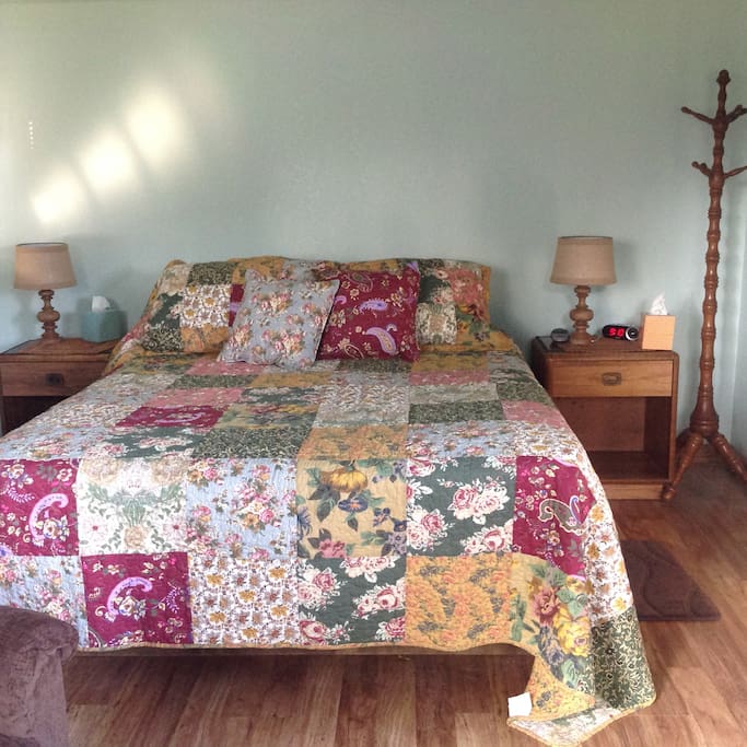 The queen sized bed has an electric blanket and two night stands on each side with reading lamps and an electric alarm clock.