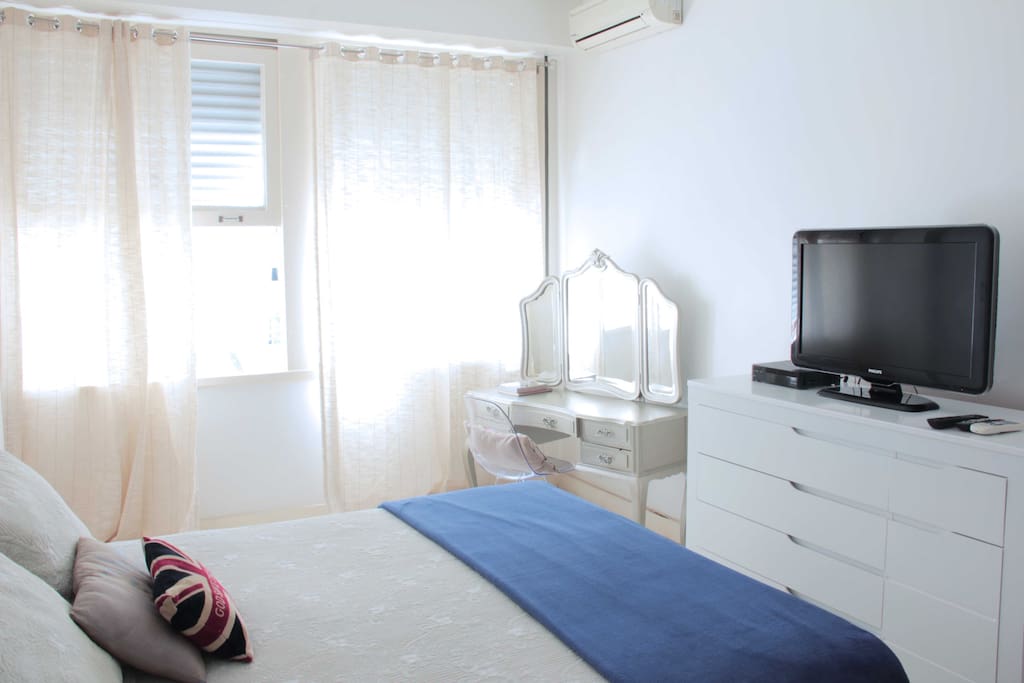 Large room , bright and airy . Queen-size bed. With cable TV and air conditioning. / Quarto amplo, bem iluminado, arejado. Cama Queen size. Com TV a cabo e ar-condicionado.