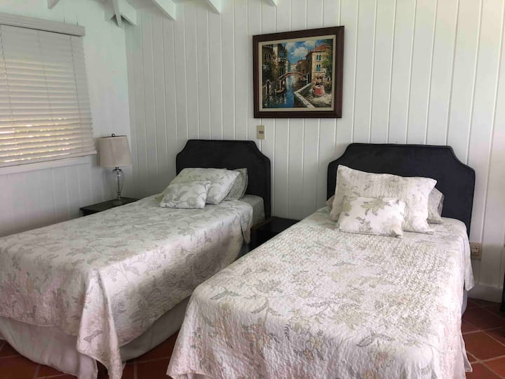 Segundo dormitorio perfecto para familias que viajan con niños. Dos camas individuales y un baño completo. Esta habitación tiene aire acondicionado, pero también tiene ventanas en tres lados para permitir el viento cruzado desde la orilla del mar para mantener la habitación cómoda y fresca. 