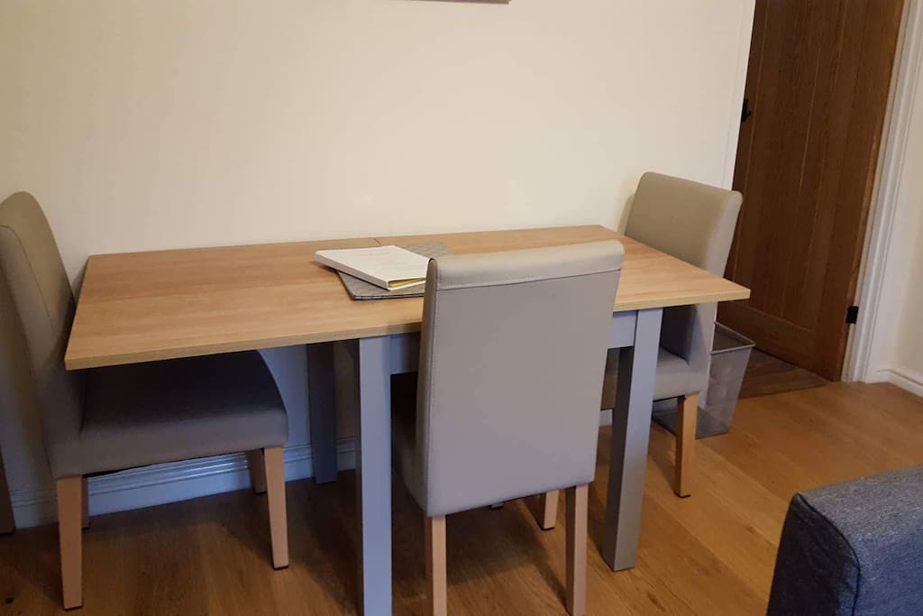 The dining table in the living room seats up to five people when extended (as shown) or up to three people when not extended.