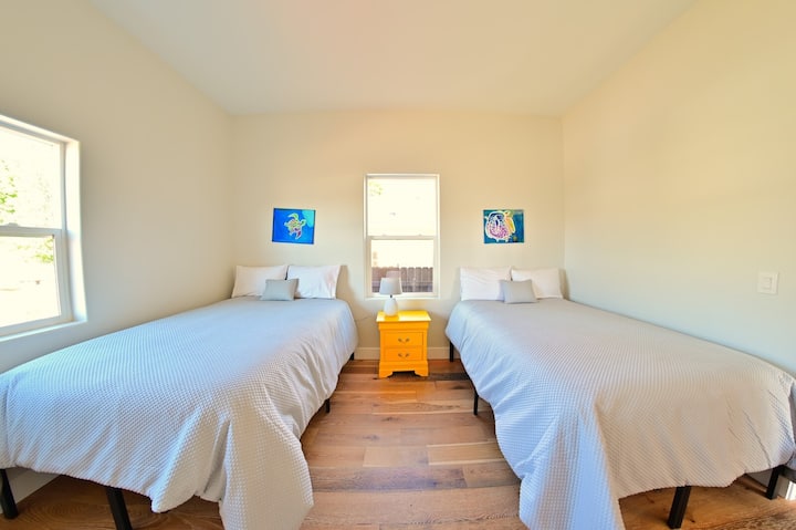 Მყუდრო საძინებელი ორი ერთადგილიანი საწოლით და ფერადი უჯრით ნათურით, იდეალურია უფროსებისთვის ან ბავშვებისთვის