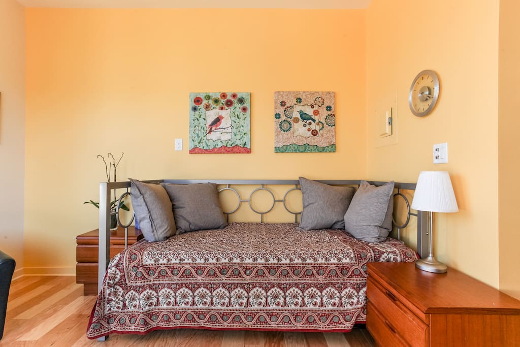 Relax and enjoy the East side of Austin. Living area with day bed / trundle (sleeps 2 here); sliding door looks out to deck with room darkening blinds.