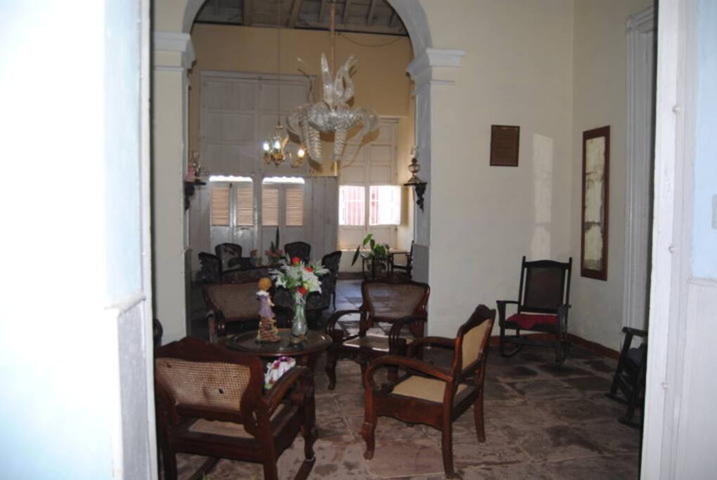 Recibidor decorado con sillas y adornos coloniales