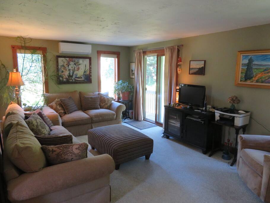 Living Room with a slider to the balcony that serves as an outdoor eating and grilling area.