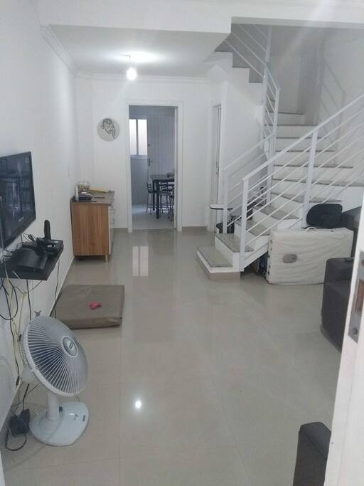 Minha sala poderá assistir tv, mais será compartilhada com moradores. Ao fundo minha cozinha, se precisar utilizar geladeira para guardar pequenas coisas, a mesa para o café da manhã, o fogão e o microondas para aquecer pratos prontos, a cozinha devendo lavar a louça se usar.