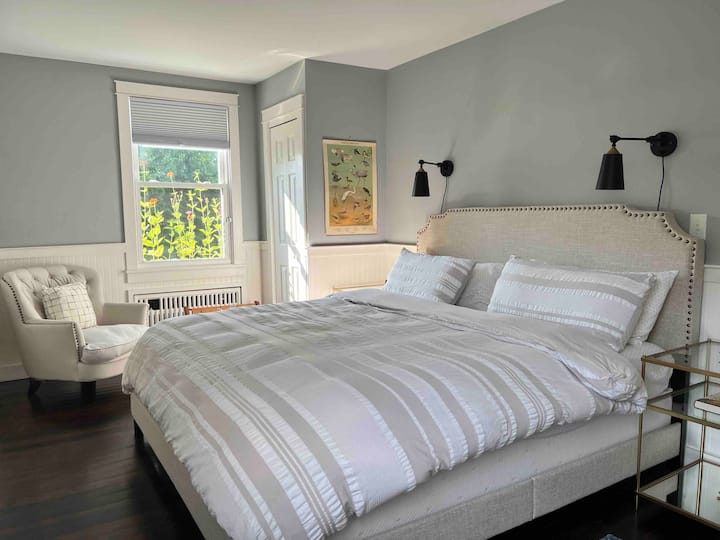 Bird King bedroom, organic cotton linens, lofted down duvet, vintage birding posters complete the room facing the pollinator garden enlivened with bird song and crickets. Optional crib available.  Closet, room darkening shades, dresser, club chair. 