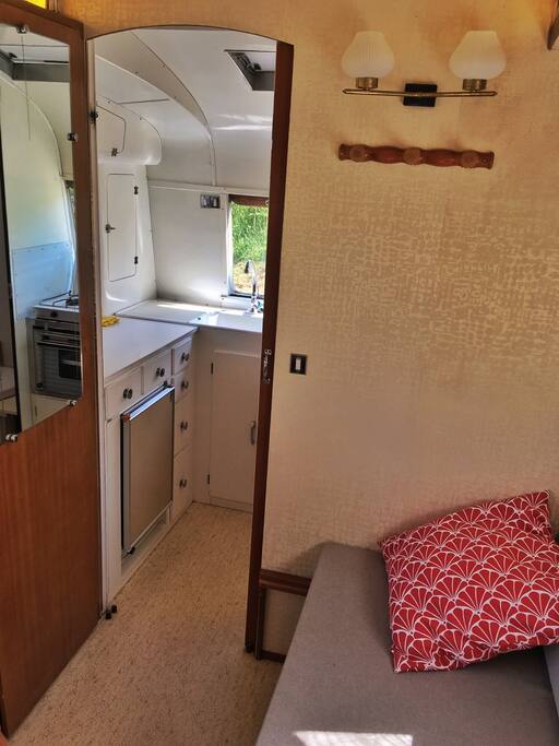 The kitchen has a fridge, an oven, running water and two gas cooking hubs.