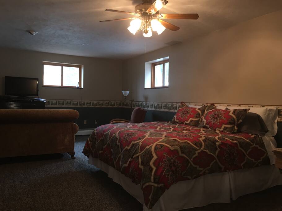 Spacious room with love seat and television.
