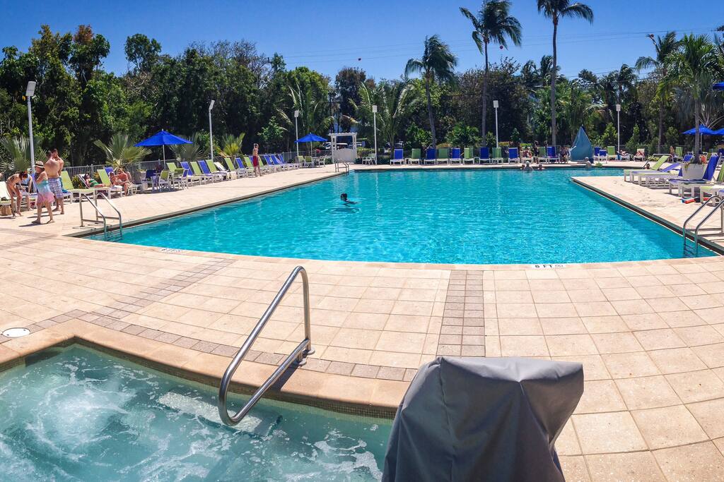 Large swimming pool with hot tub a tub & tiki bar.