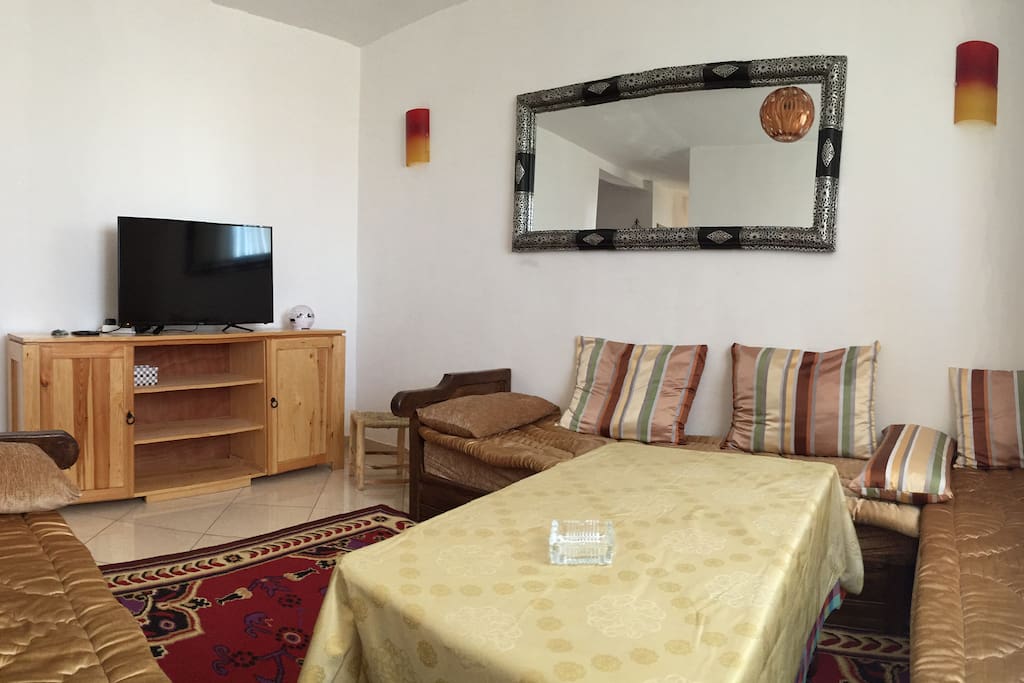 Salon marocain traditionnel avec rangement et TV