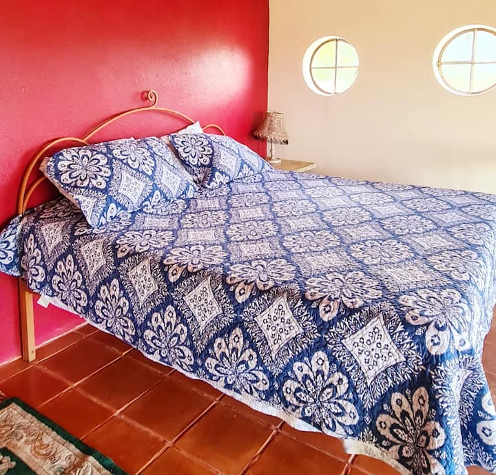 מיטת קינג סייז עם הרבה כריות בחדר השינה