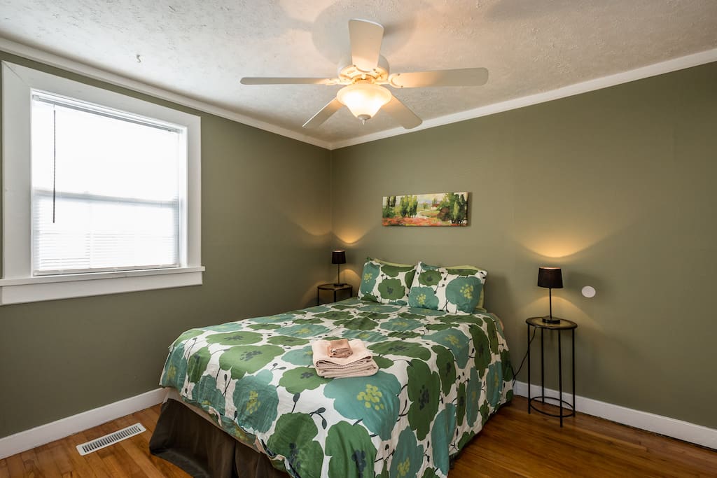 The 1st bedroom offers a queen-size bed and green decor