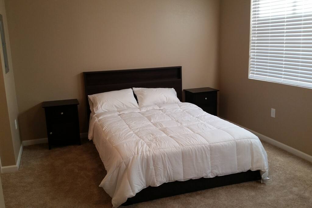 Comfy queen sized bed and bedside luggage rack.
