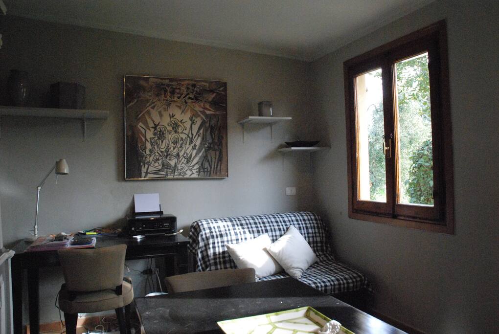 Divano letto una piazza 1/2 separato dalla camera da letto da una bella tenda di cotone pesante.