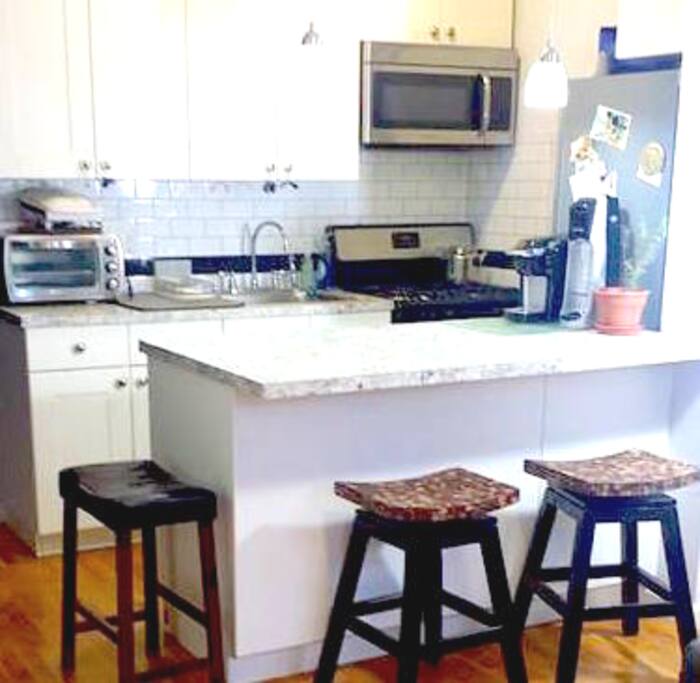 Modern Eat in Full Kitchen!~ Dining Kitchen island with 4 stools, State of the art stainless steel appliances. Beautiful oak hardwood floors throughout home.