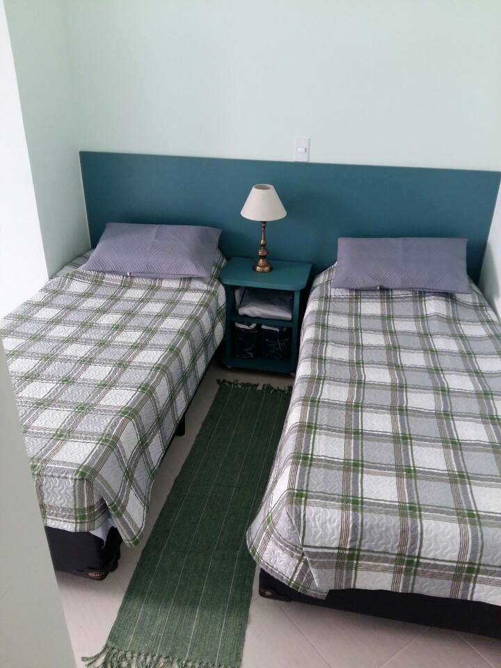 Duas camas de solteiro e criado mudo com rodinhas