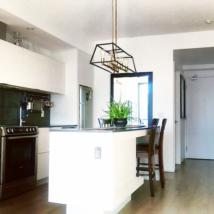 This unit features a stunning mid-century modern kitchen that is fully equipped for your convenience.