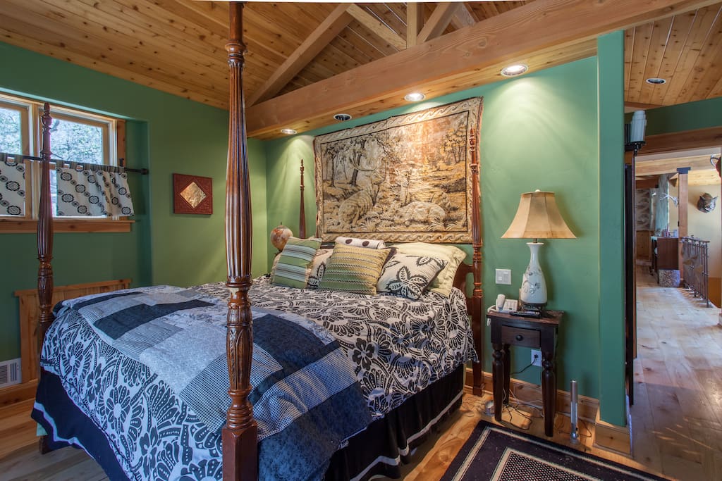 Master bedroom with a king size bed and a large window with beautiful views.