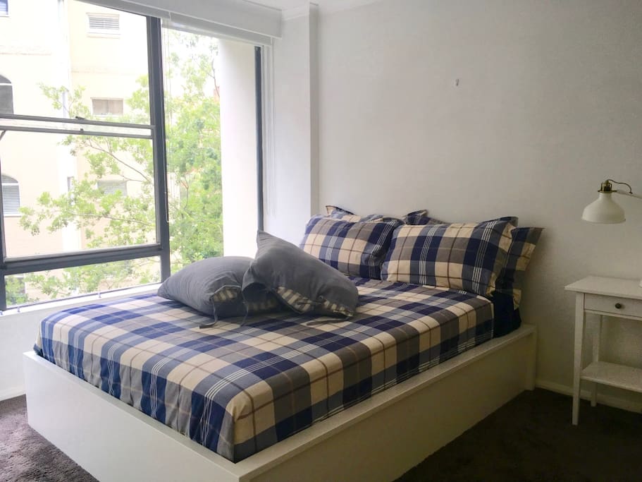Bedroom with queen bed and blackout blinds