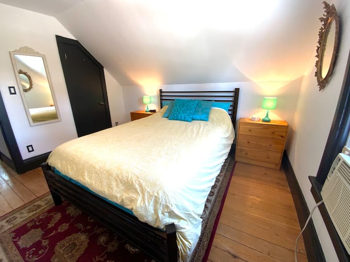 Cama tamaño queen en el dormitorio principal. También hay una unidad de aire acondicionado en la ventana para esos días y noches muy calurosos.