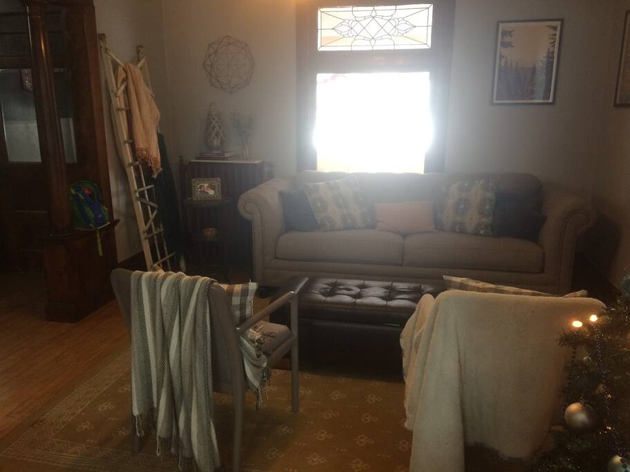 The living room has an electric fireplace, 7-foot couch, and two chairs.