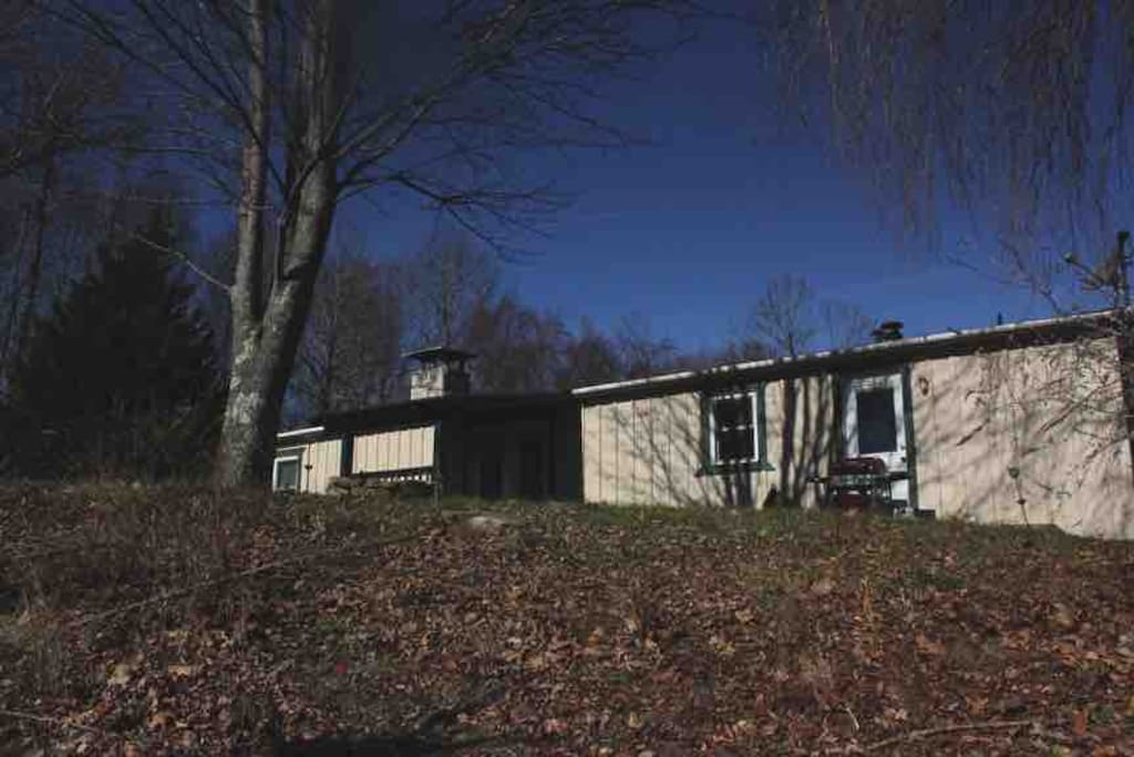 The one-story home has a covered entrance and a front yard that overlooks rolling pastures.