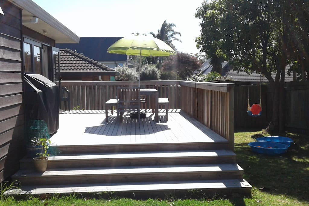 Large sunny north facing deck with BBQ and outdoor table and chairs.