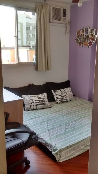 Silent room with two single mattresses side by side, desk, fan and wardrobe.