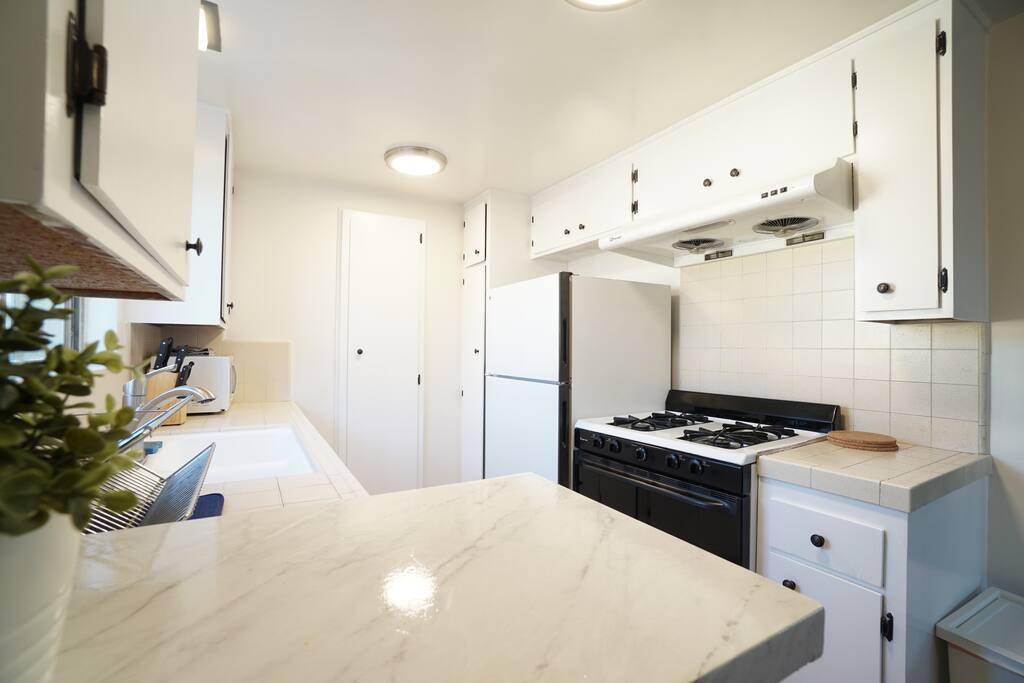 Full kitchen with stove, oven, fridge, and ventilation fan. Handsome cabinet with new hardware